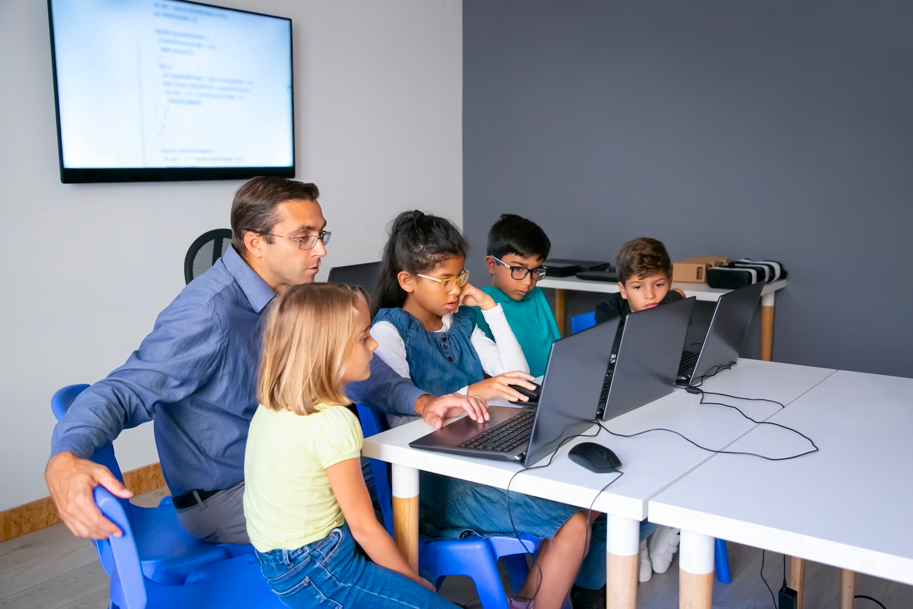 Profesor introduciendo la tecnología a los alumnos como parte de sus procedimientos en el aula