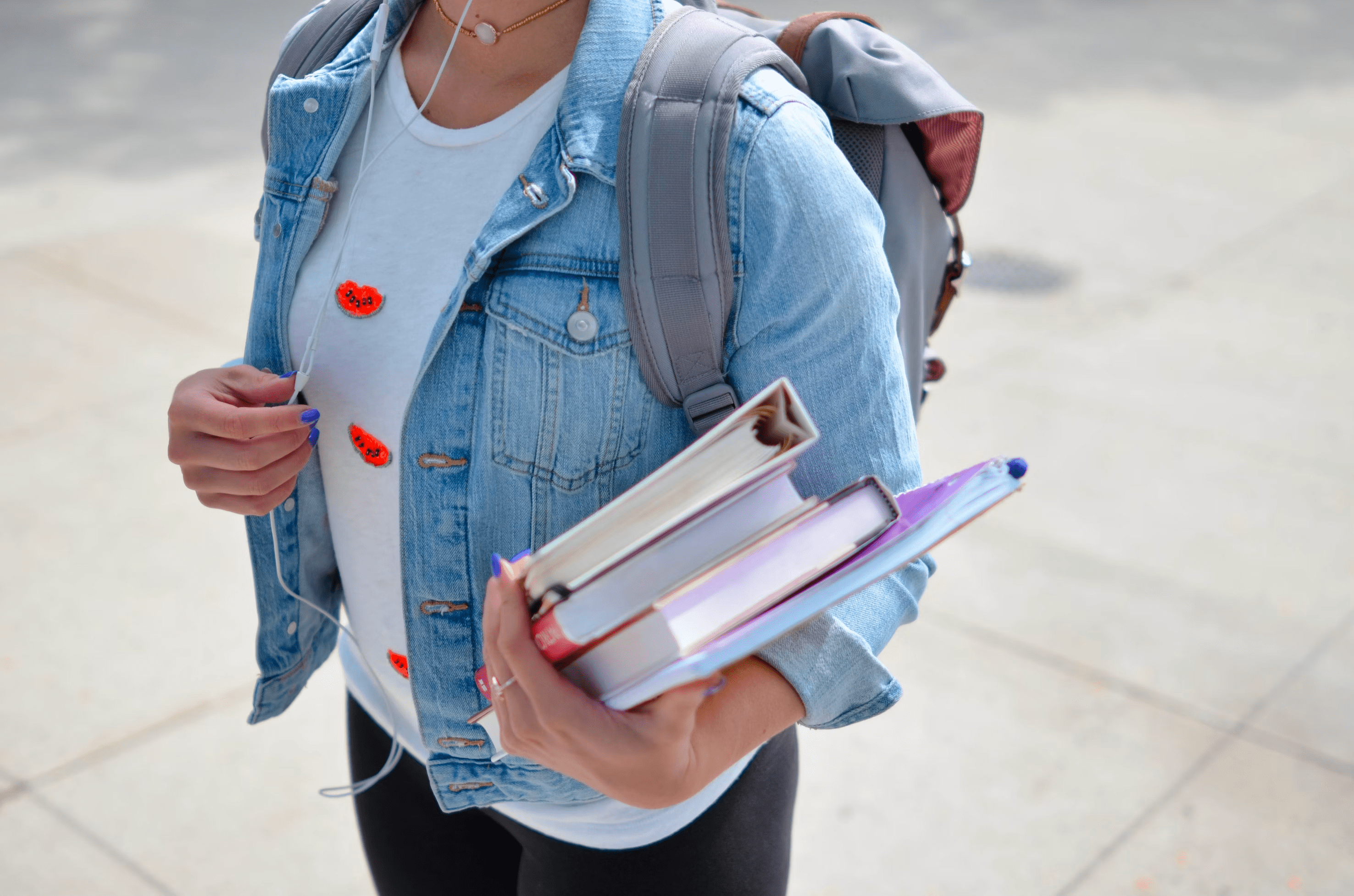 Estudiante de secundaria con libros en la mano, escuchando música